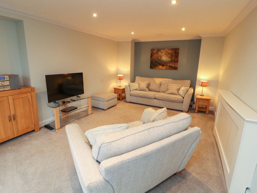 A living room with a television and seating at Cragfell Cottage Cartmel Fell