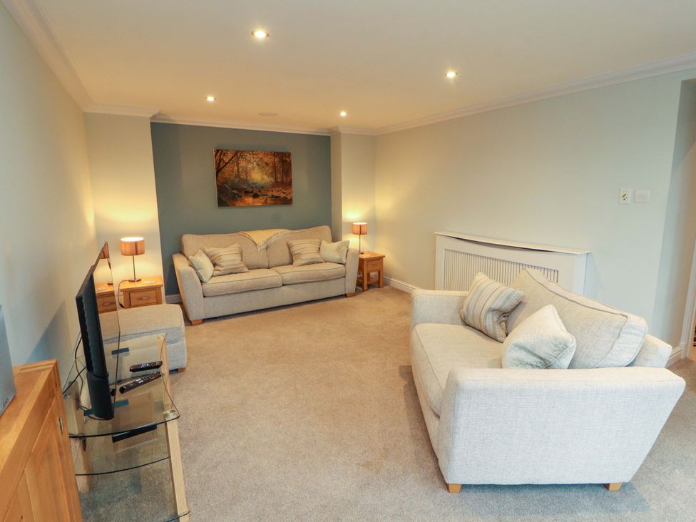 A living room with sofa and television at Cragfell Cottage in Cartmel Fell