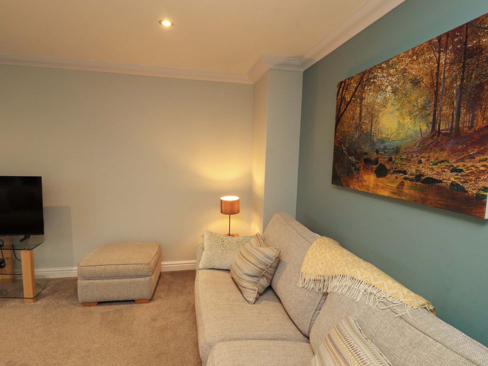 A living room with a sofa and a television at Cragfell Cottage Cartmel Fell