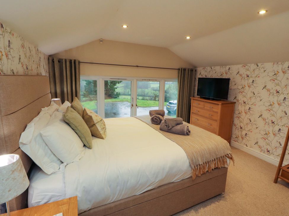 A bedroom with a bed and a television at Cragfell Cottage in Cartmel Fell