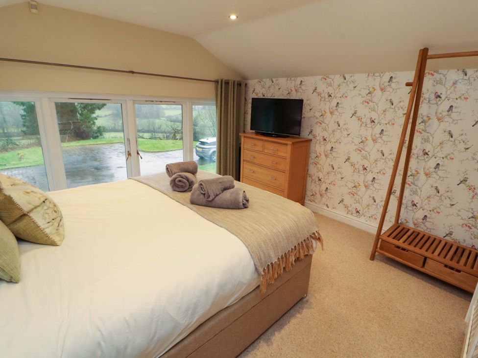 A bedroom with a bed and television at Cragfell Cottage Cartmel Fell