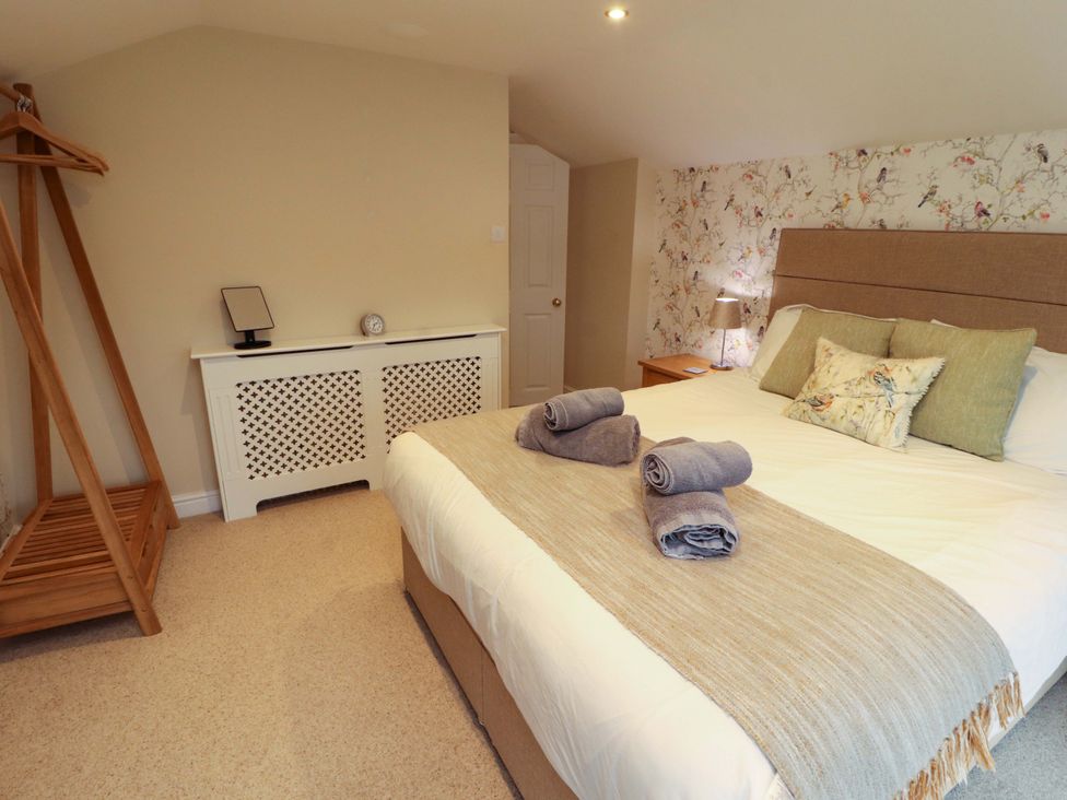 A bedroom with a bed and nightstand at Cragfell Cottage in Cartmel Fell