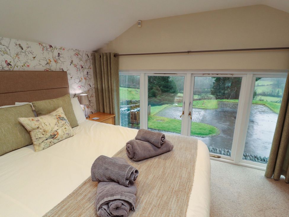 A bedroom with a bed and towels at Cragfell Cottage, Cartmel Fell