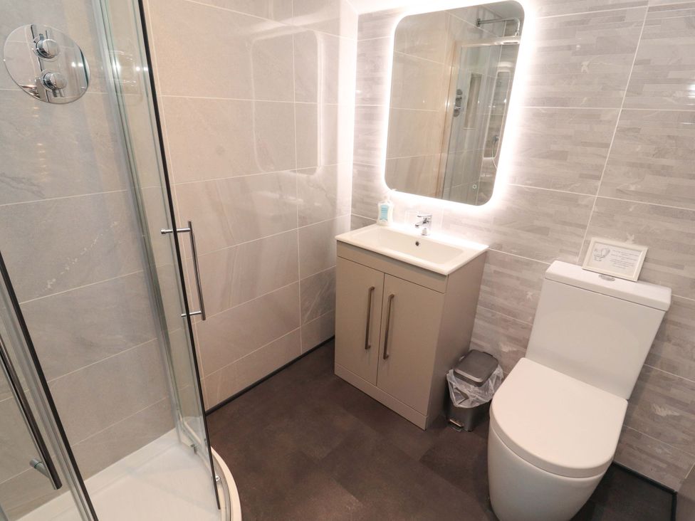 A bathroom with a shower, sink, and toilet at Cragfell Cottage, Cartmel Fell