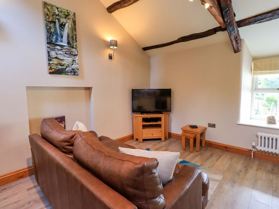 A living room with a television and sofa at Abbots Reading Mews 2 Grizedale