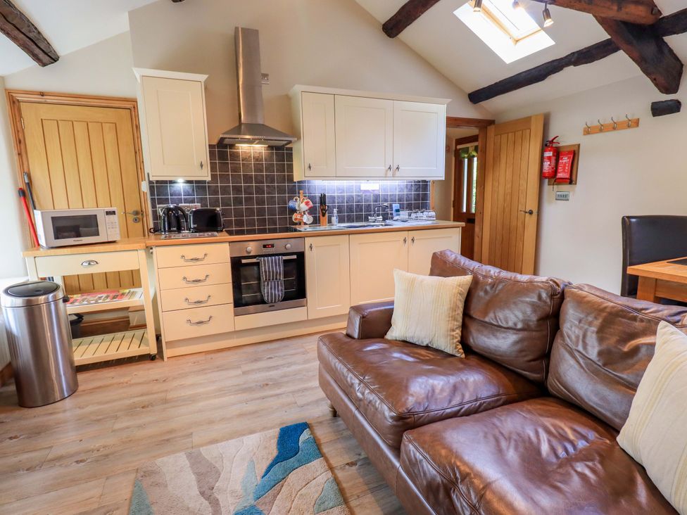 A kitchen with cabinets and a sofa at Abbots Reading Mews 2 Grizedale