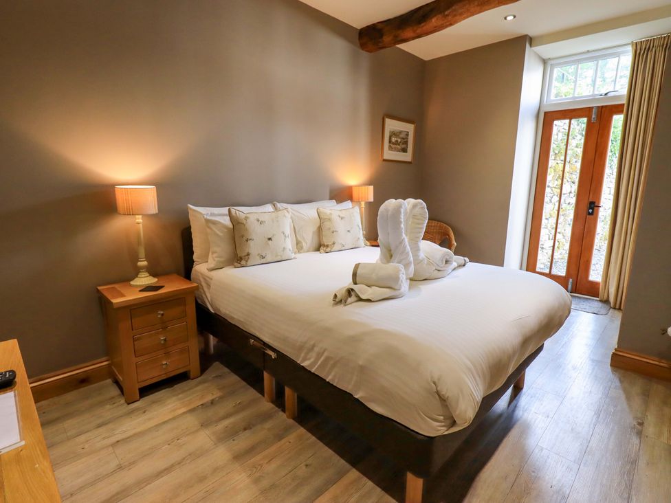 A bedroom with a bed and bedside table at Abbots Reading Mews 2 in Grizedale