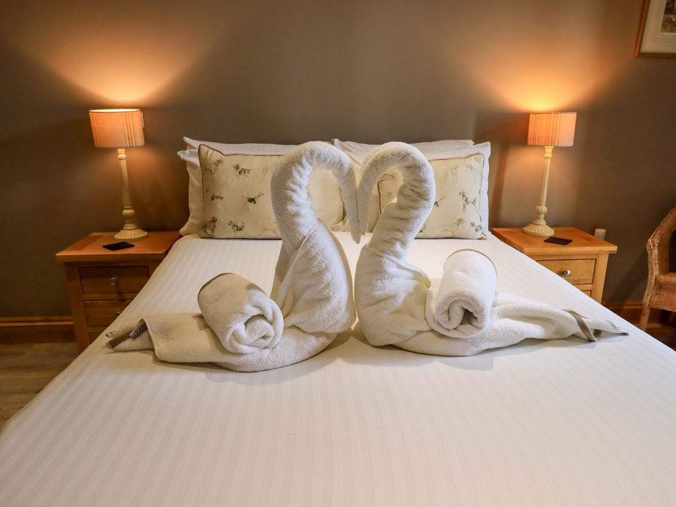 A bedroom with towel swans on the bed at Abbots Reading Mews 2 in Grizedale