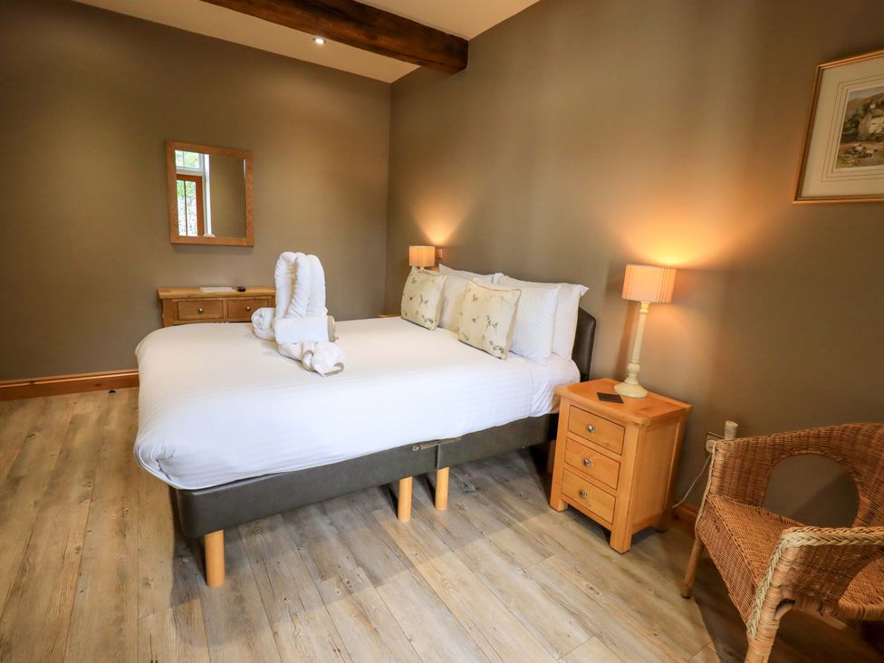 A bedroom with a bed and nightstand at Abbots Reading Mews 2 in Grizedale