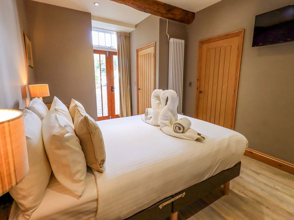 A bedroom with a bed and wooden furniture at Abbots Reading Mews 2 in Grizedale
