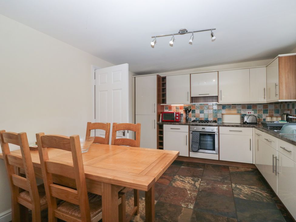 A kitchen with a dining table and chairs at Woodside West in Bowness