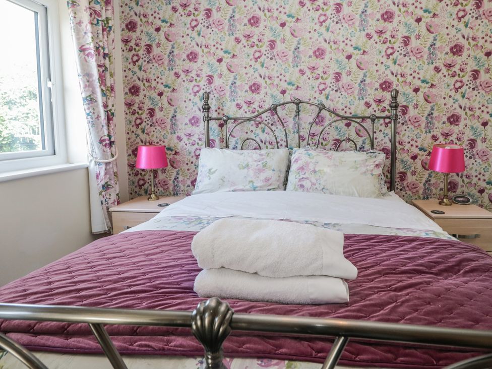 A bedroom with a bed and bedside tables at Woodside West in Bowness