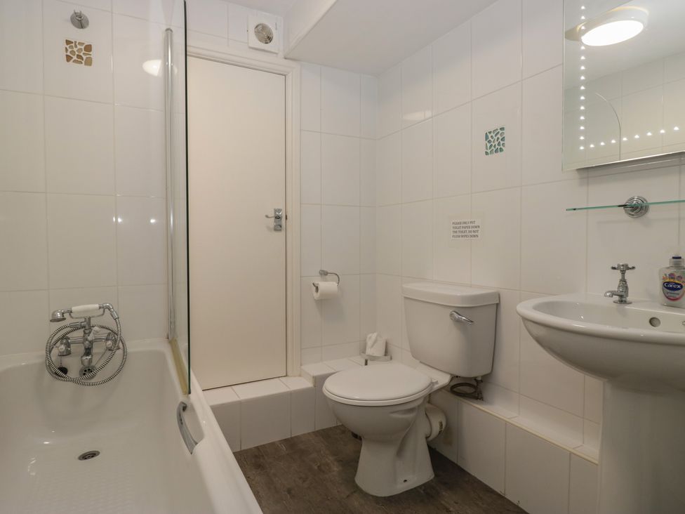 A bathroom with a bathtub, toilet, and sink at Woodside West Bowness
