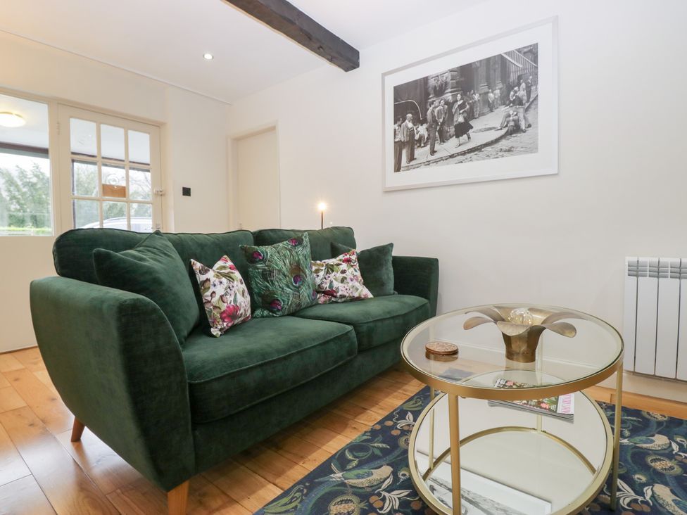 A living room with a sofa and coffee table at Corner Cottage in Troutbeck