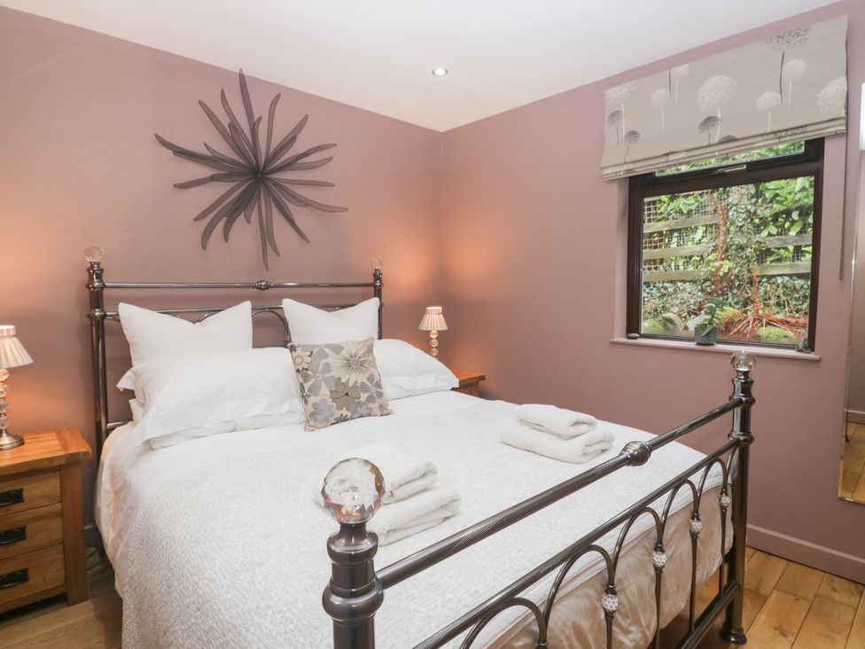 A bedroom with a bed and nightstands at Corner Cottage in Troutbeck