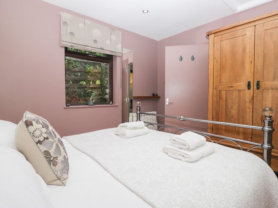 A bedroom with a bed and towels at Corner Cottage, Troutbeck