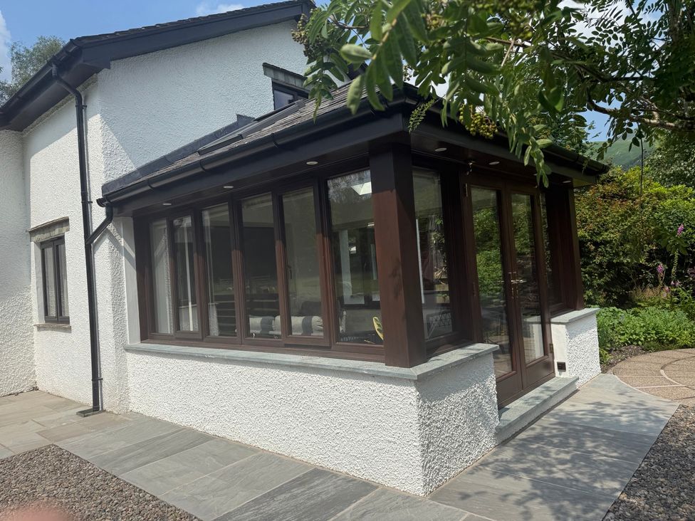 A conservatory with multiple windows at Rowanberry Cottage in Grasmere
