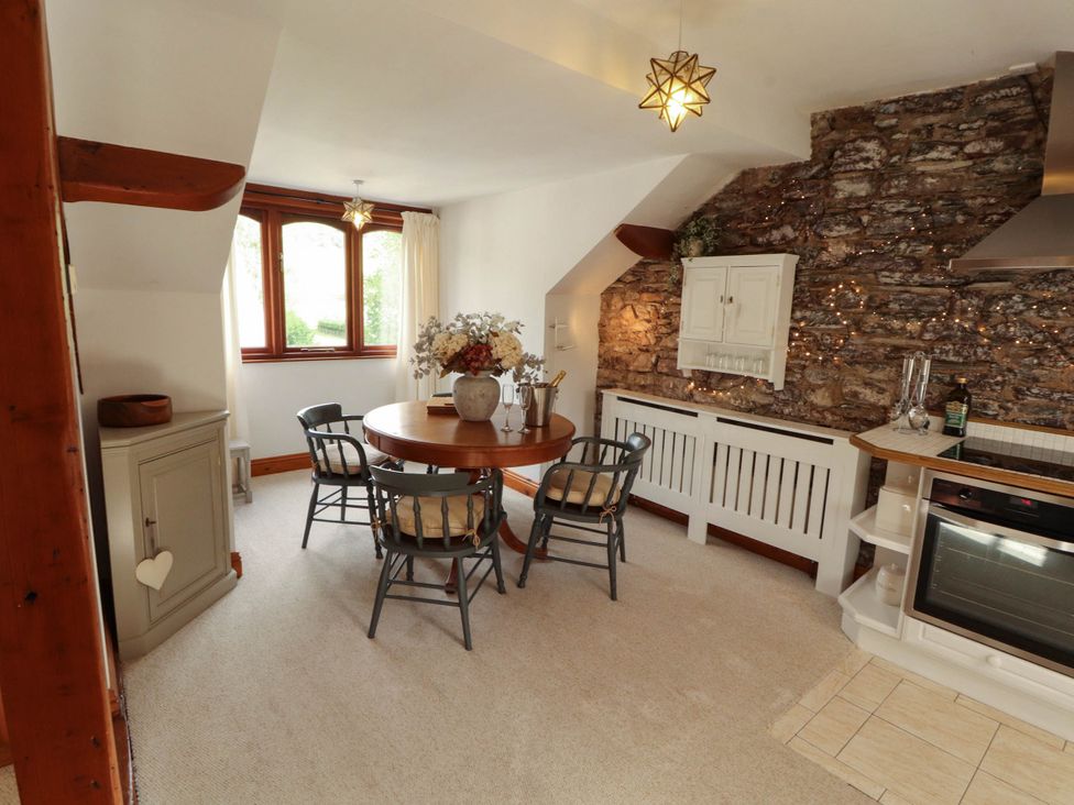 A dining area with a round table and chairs at High Raise in Grasmere