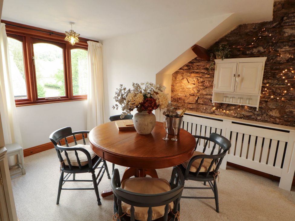 A dining room with a round table and chairs at High Raise in Grasmere