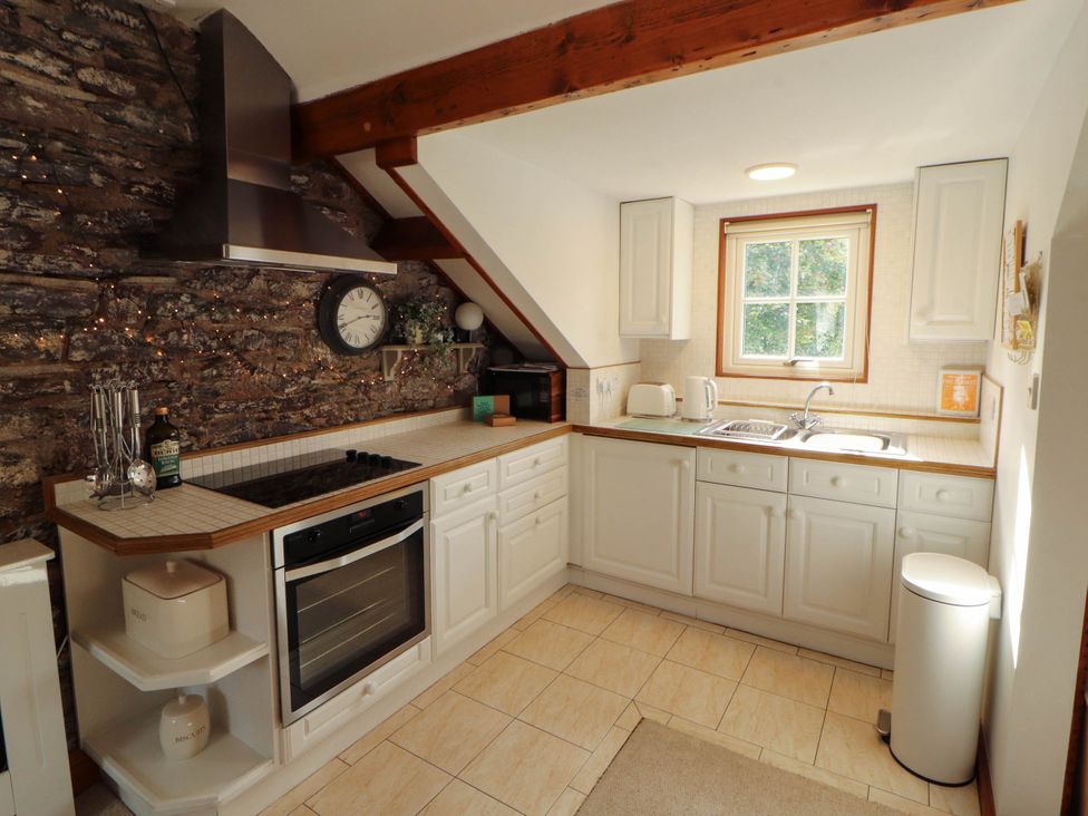 A kitchen with a stove, oven, sink and window at High Raise in Grasmere