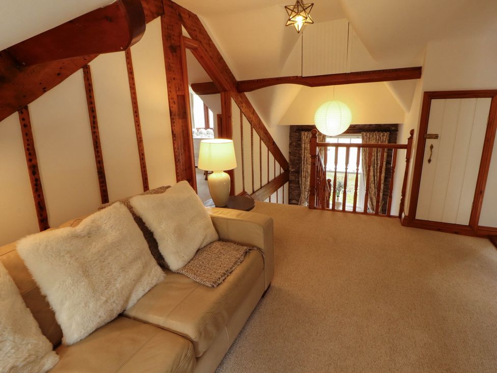 A living room with staircase and sofa at High Raise in Grasmere