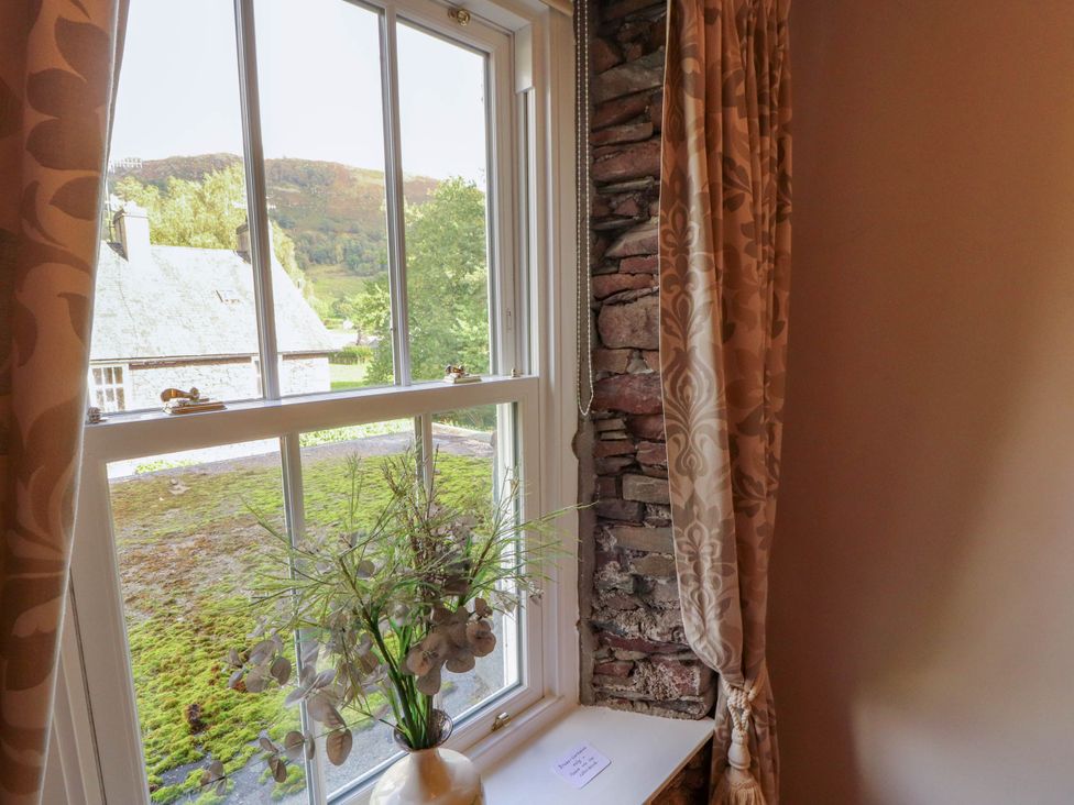 A window with curtains and a plant at High Raise in Grasmere