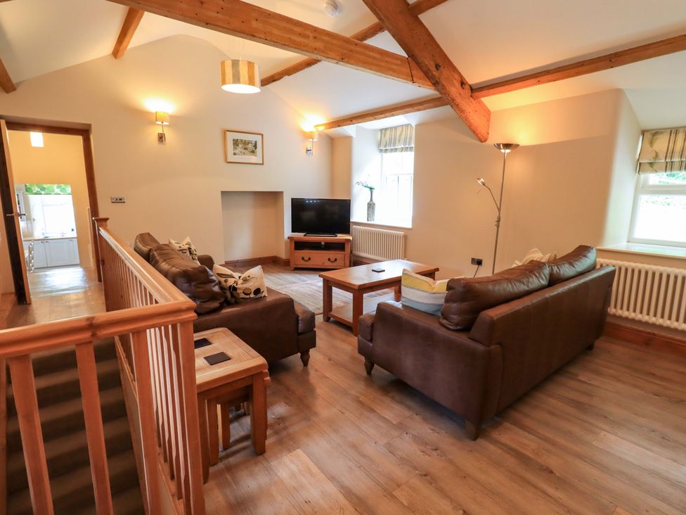 A living room with a sofa and coffee table at Abbots Reading Cottage, Lakeside