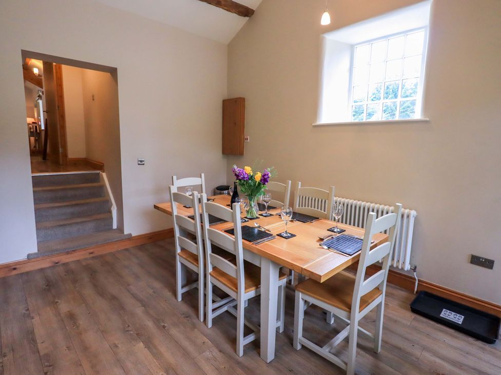 A dining room with a table and chairs at Abbots Reading Cottage, Lakeside