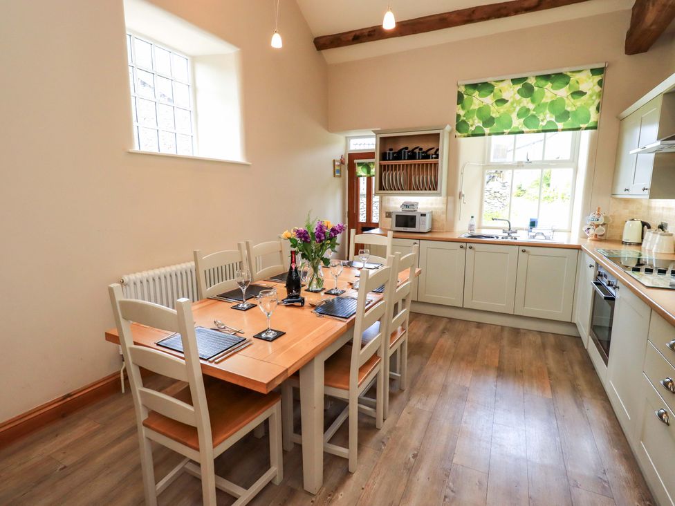 A kitchen with a dining table set up at Abbots Reading Cottage Lakeside