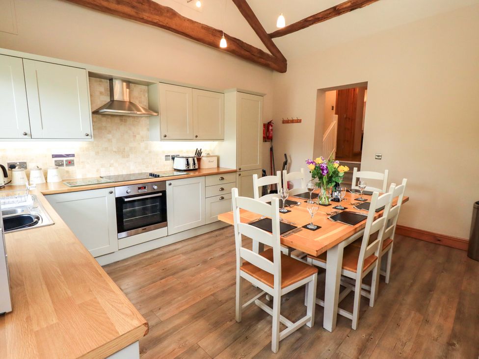 A kitchen with a dining table and chairs at Abbots Reading Cottage Lakeside