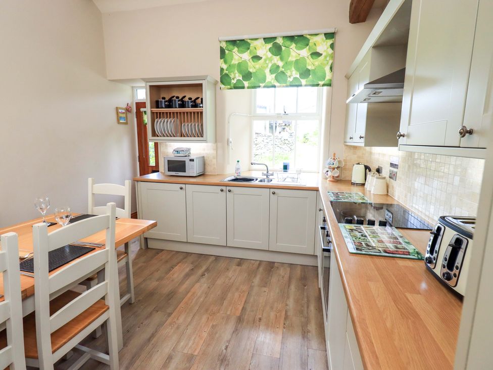 A kitchen with a table and chairs at Abbots Reading Cottage in Lakeside