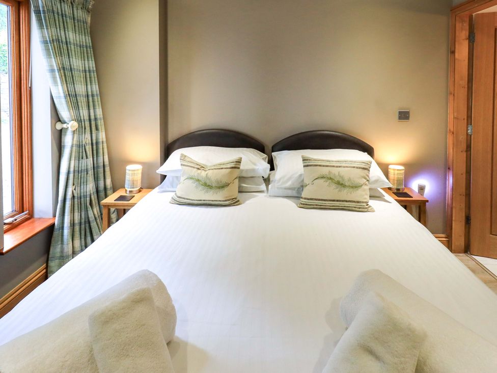 A bedroom with a double bed and bedside tables at Abbots Reading Cottage in Lakeside
