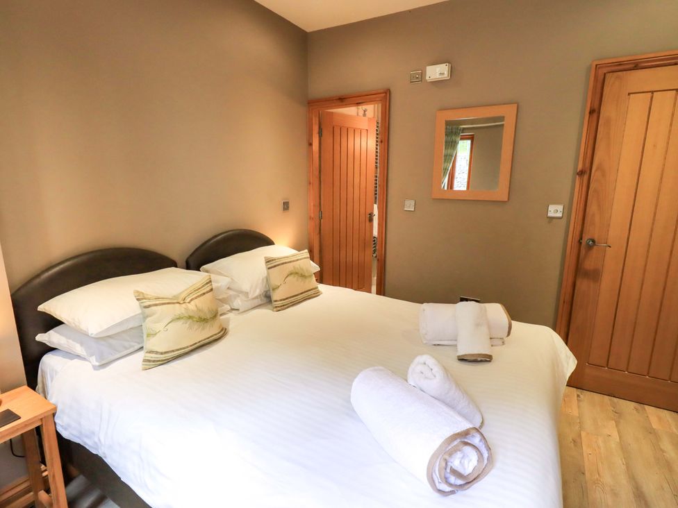 A bedroom with a double bed and towels at Abbots Reading Cottage in Lakeside