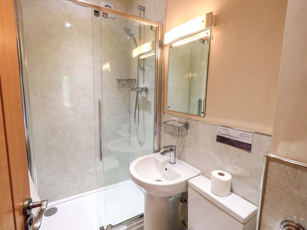 A bathroom with a shower, sink, and toilet at Abbots Reading Cottage Lakeside