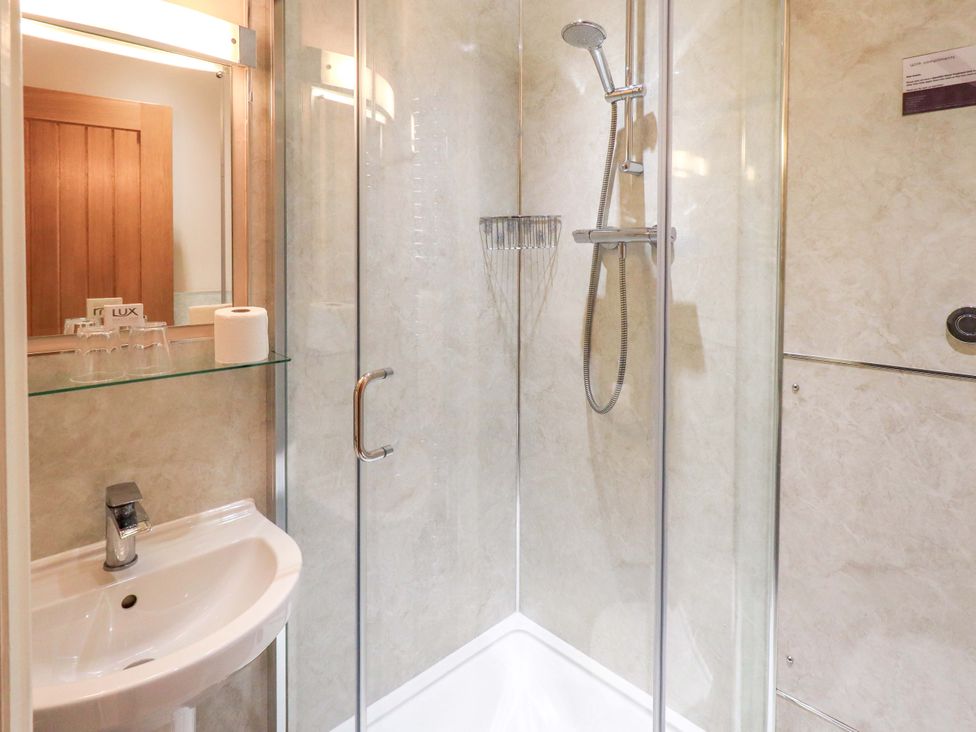 A bathroom with a shower and sink at Abbots Reading Cottage Lakeside