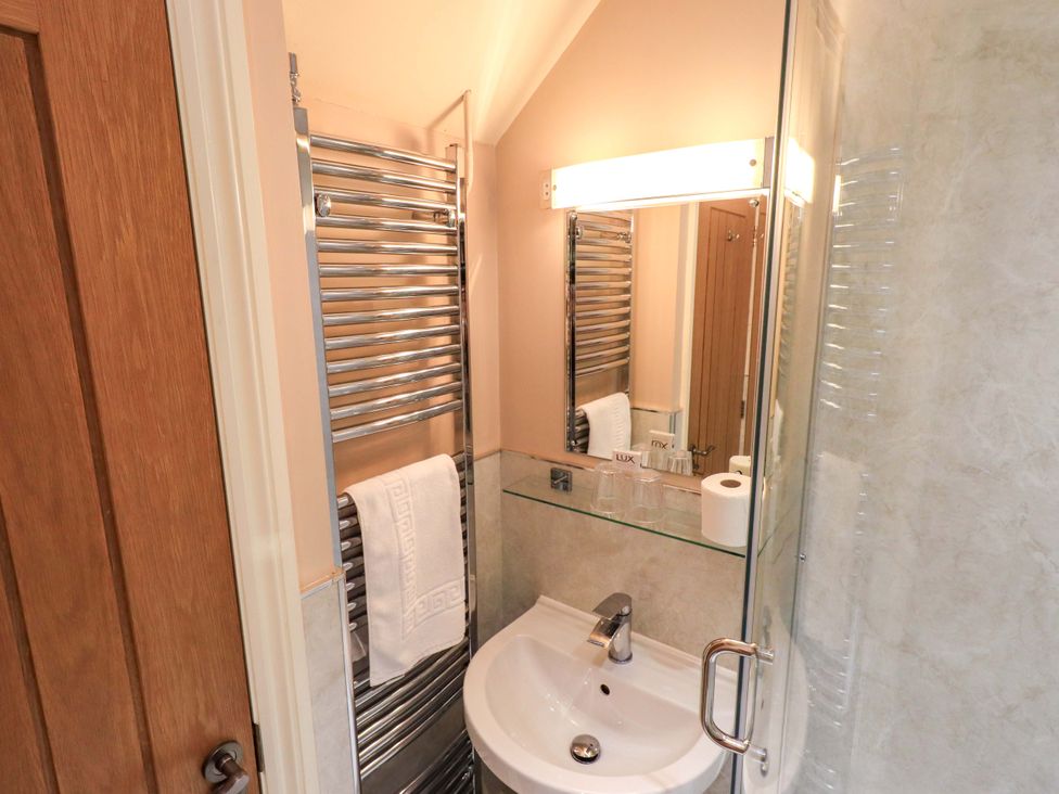 A bathroom with a hand basin and towel rail at Abbots Reading Cottage in Lakeside