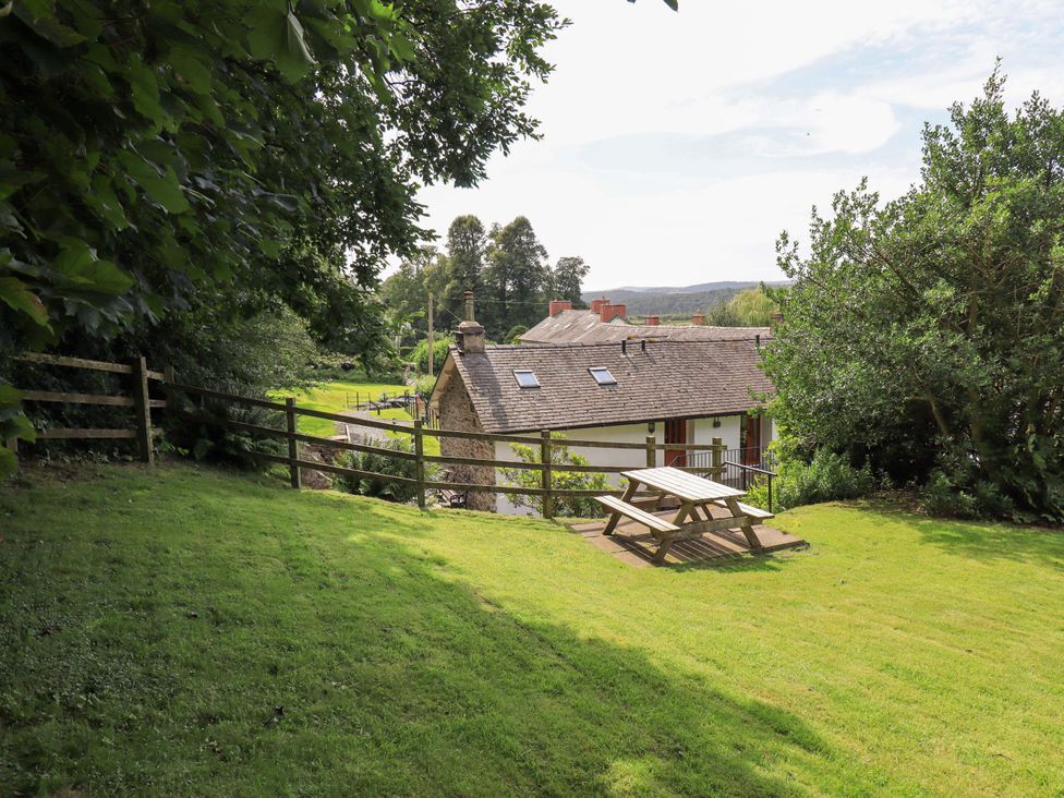 A house with a picnic table in the outdoor area at Abbots Reading Cottage Lakeside