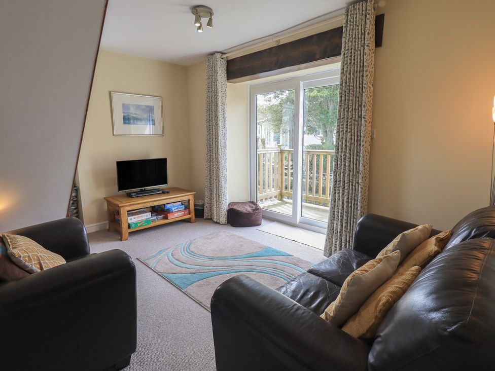 A living room with a television and sliding doors at A River Runs By in Staveley