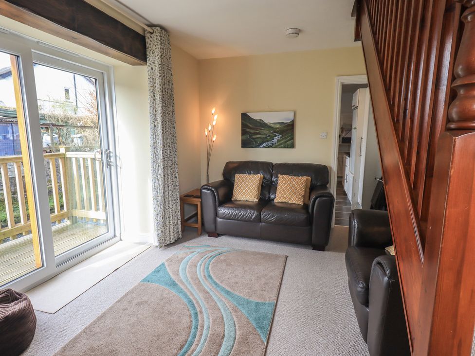 A living room with a sofa and armchair at A River Runs By in Staveley