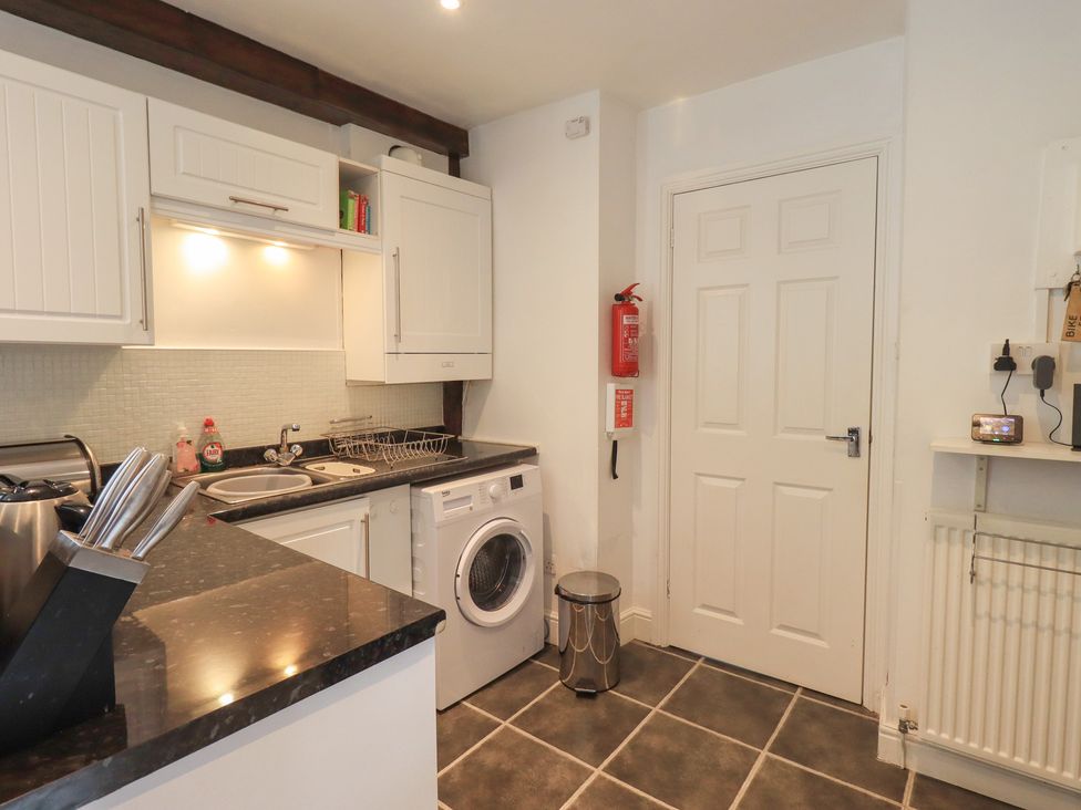 A kitchen with a washing machine and sink at A River Runs By in Staveley