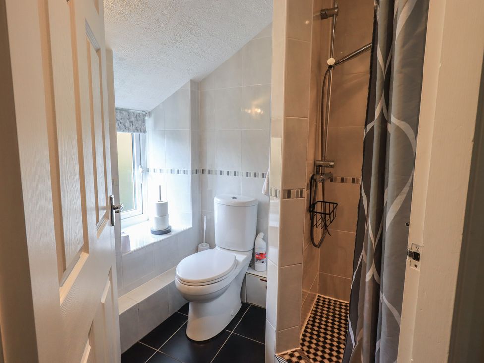 A bathroom featuring a toilet, sink, and shower at A River Runs By in Staveley