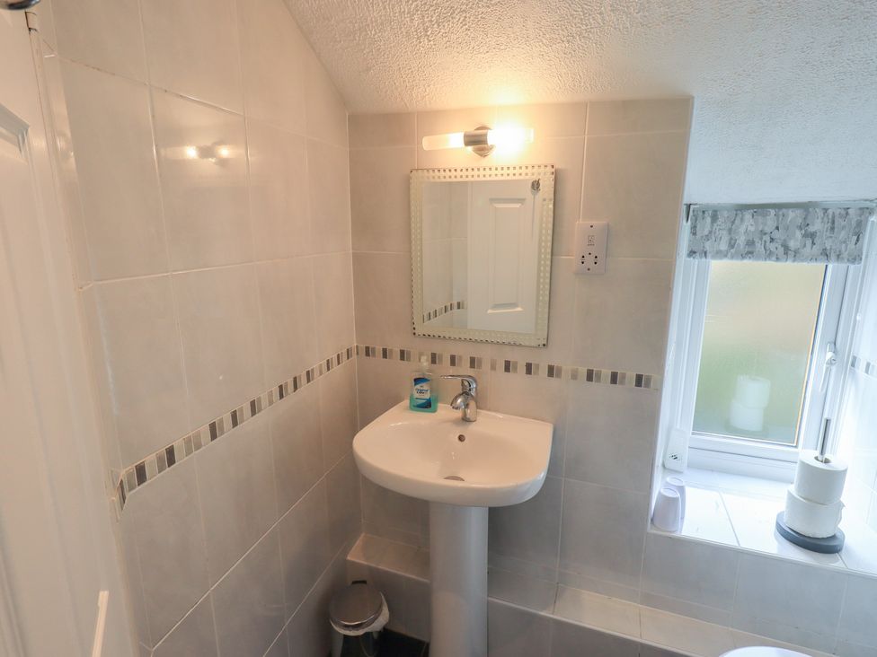 A bathroom with a sink and mirror at A River Runs By Staveley