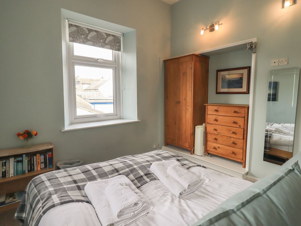 A bedroom with a double bed and wooden furniture at A River Runs By Staveley