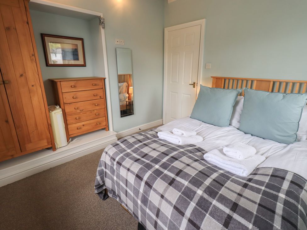 A bedroom with a bed and storage furniture at A River Runs By Staveley