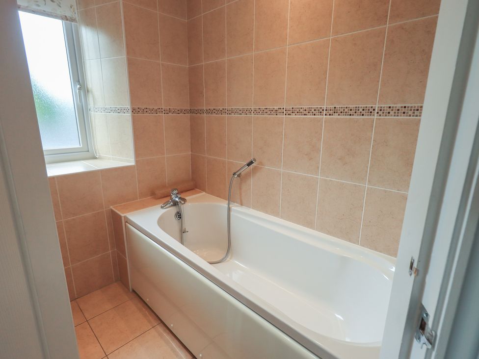 A bathroom with a bathtub and window at A River Runs By in Staveley