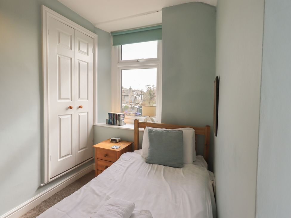 A bedroom with a single bed and window at A River Runs By Staveley