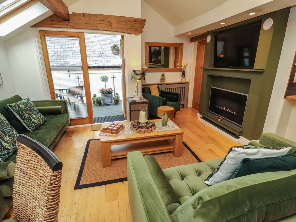 A living room with a sofa and fireplace at Workshop Cottage in Bowness