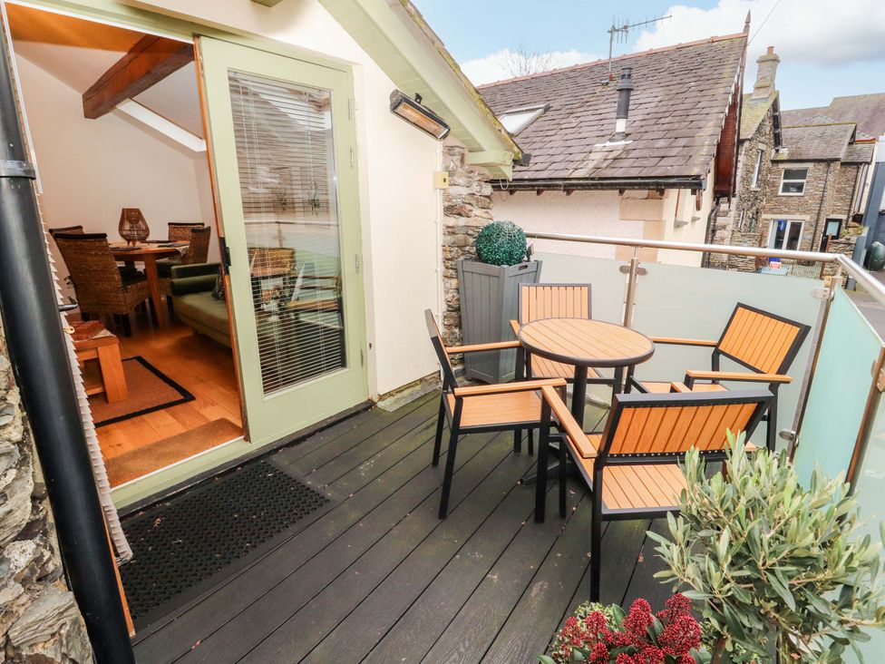 A balcony with a table and chairs at Workshop Cottage in Bowness