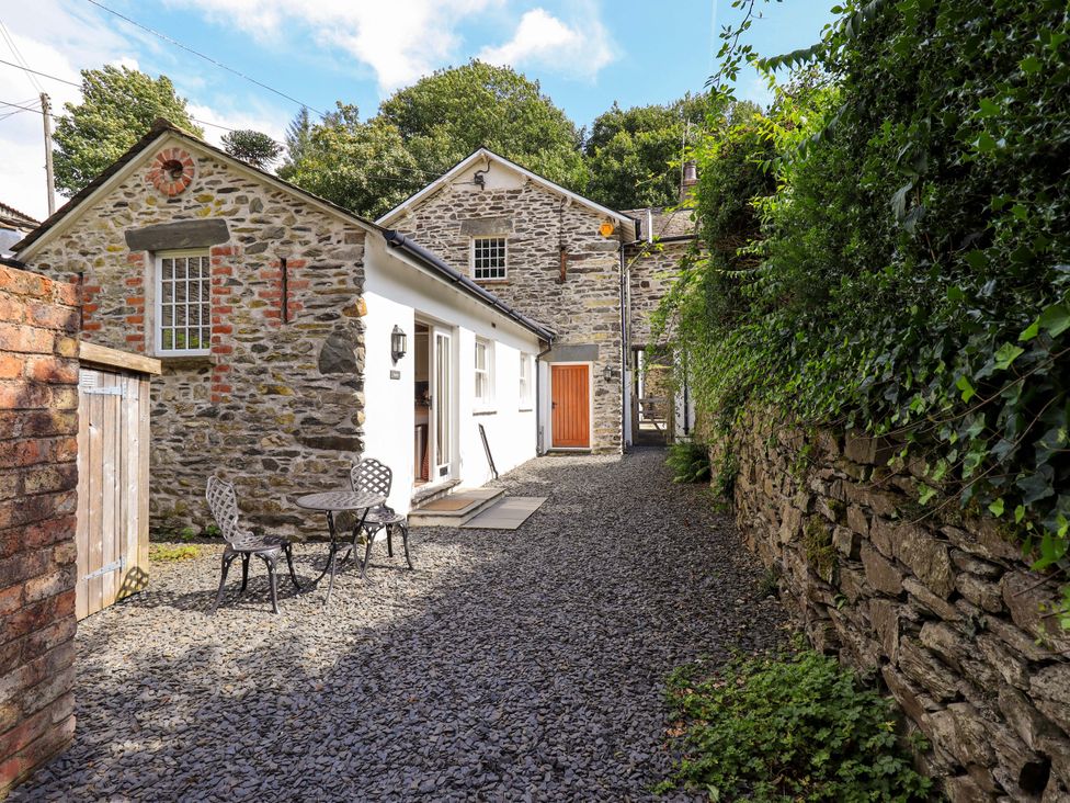 An outdoor area with a stone house and seating at Abbots Reading Suite, Lakeside