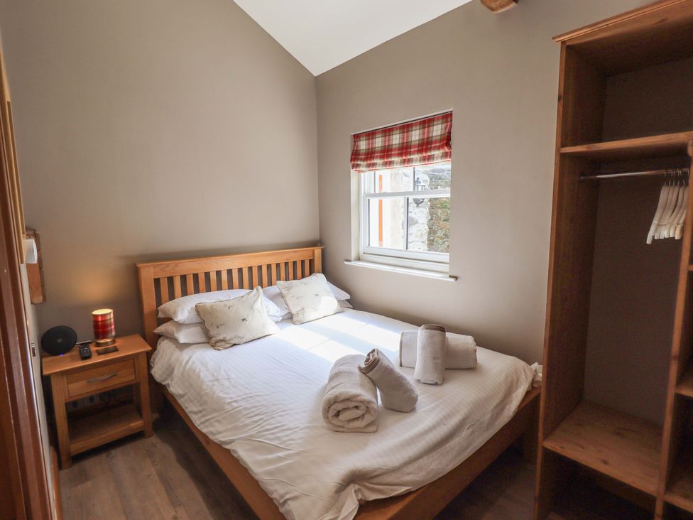 A bedroom with a bed and nightstand at Abbots Reading Suite Lakeside